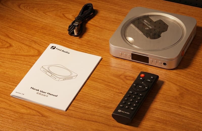 El reproductor Merak junto al cable USB de alimentación, el manual de usuario y el control remoto.