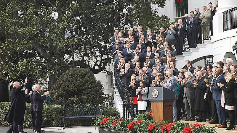 Donald Trump celebra con los legisladores republicanos después de la promulgación de la ley impositiva