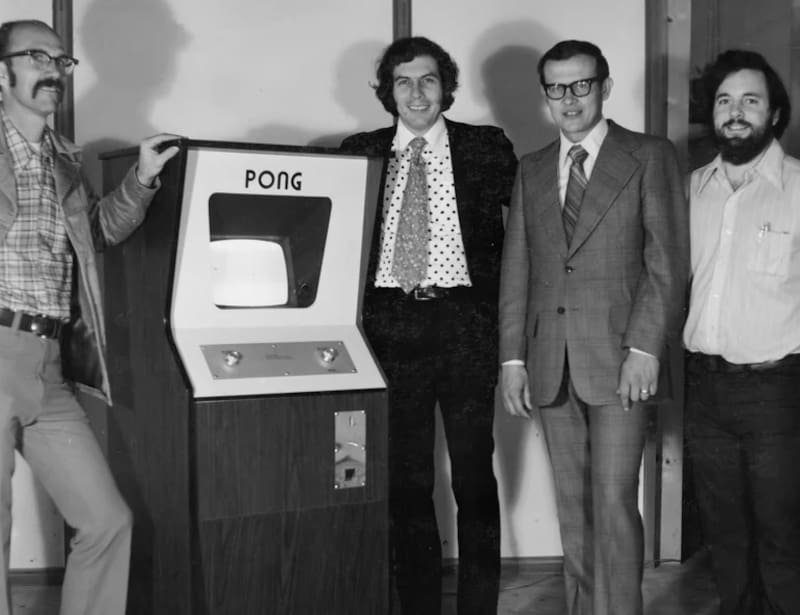 Ted Dabney, Nolan Bushnell, Fred Marincic (finanzas) y Al Alcorn junto a la máquina Pong.
