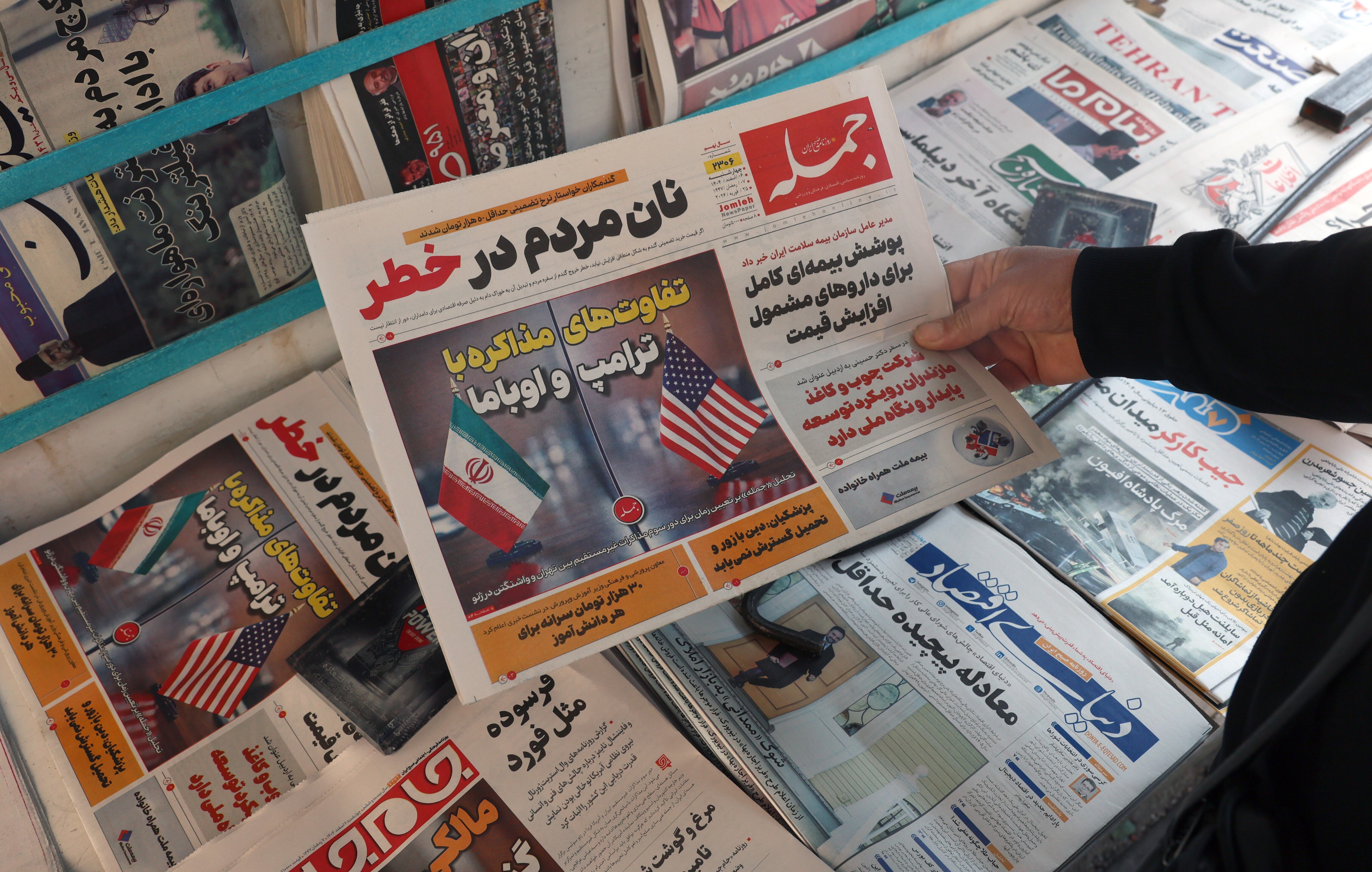 Un hombre sostiene el diario Jomleh con un titular sobre las diferencias entre negociar con Trump y Obama, en vísperas de nuevas conversaciones entre Irán y EE.UU. en Ginebra.