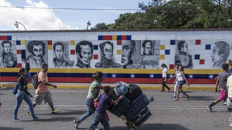 Venezuelanos cruzan con su equipaje el Puente Internacional Simon Bolivar hacia Cucuta, Colombia