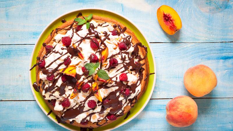 Pastel de esponja con duraznos y frambuesas, una receta ideal para deleitarse con un postre en los días de calor.