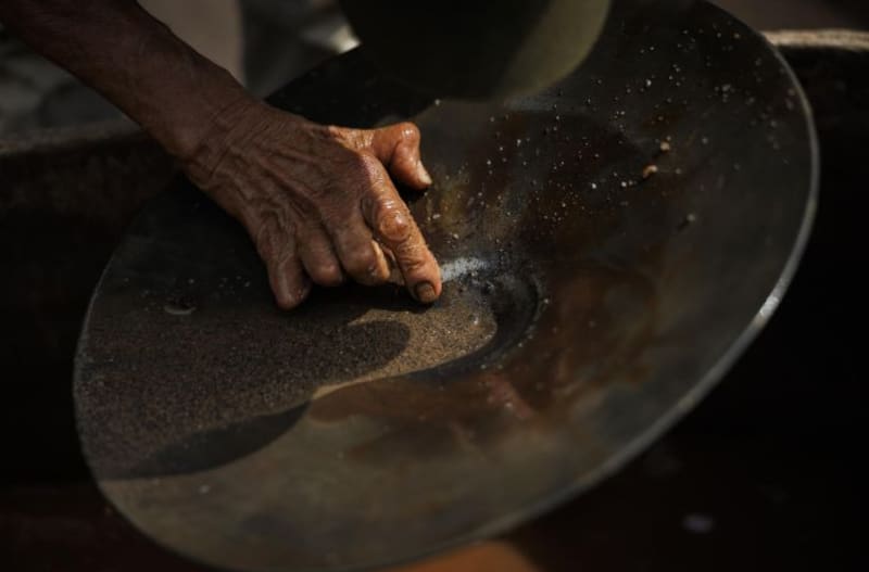 El garimpeiro Zezão analizando el material de mineral extraído del subsuelo para verificar la proporción de oro en Serra Pelada. (Foto: EFE).