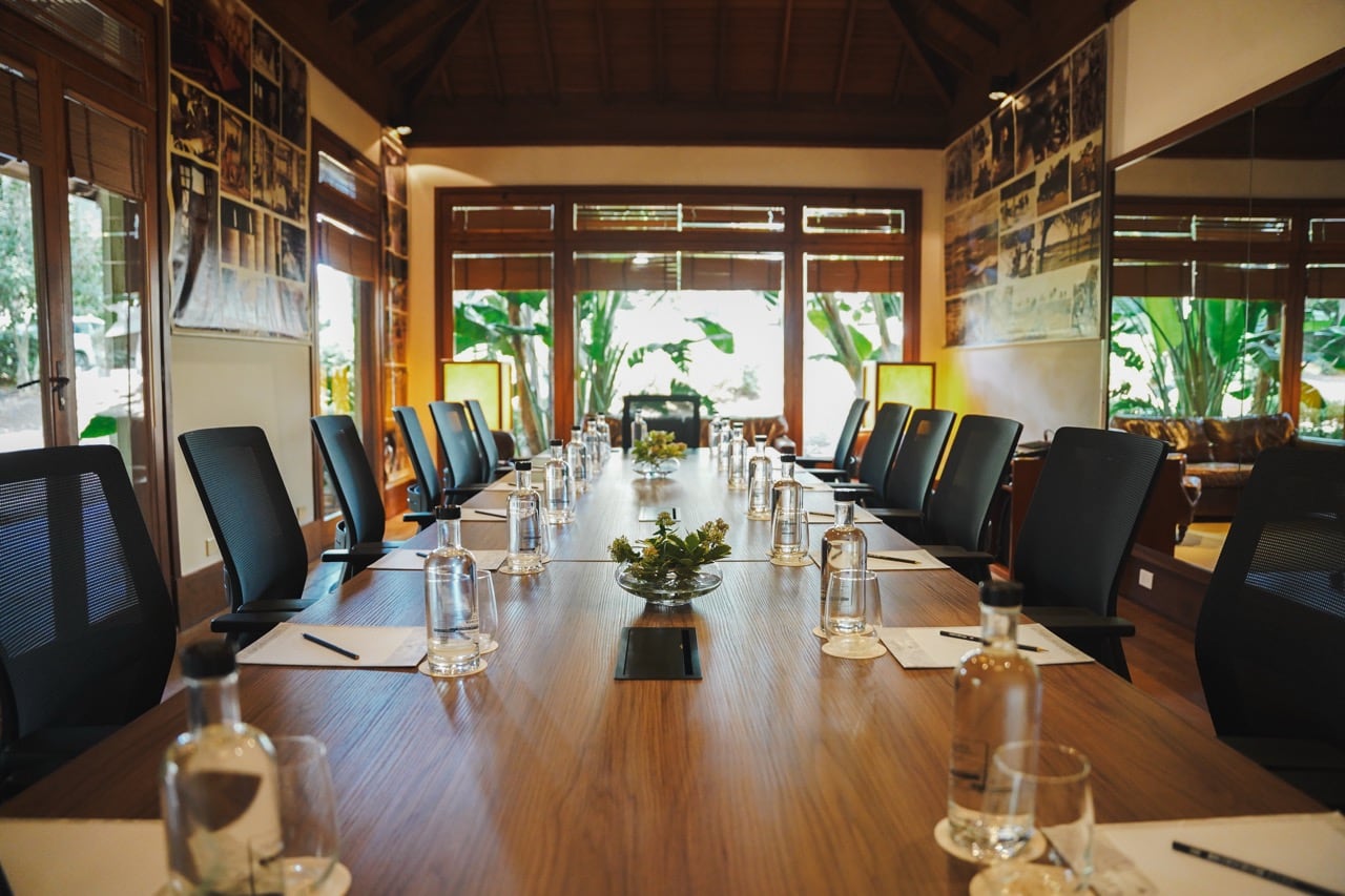 Sala ejecutiva Ceibo Zen: mesa larga de madera con sillas ejecutivas, fotografías en blanco y negro en las paredes y vista al exterior.