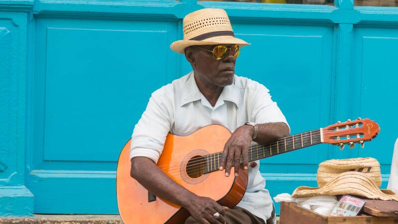 Músico callejero actúa para turistas y propinas en La Habana Vieja, Cuba.