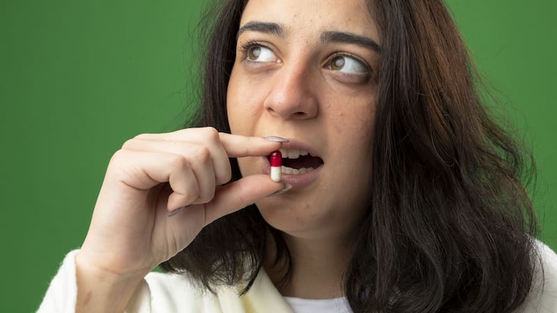 Una mujer toma cápsulas sin conocer los riesgos ocultos en algunos suplementos dietarios.