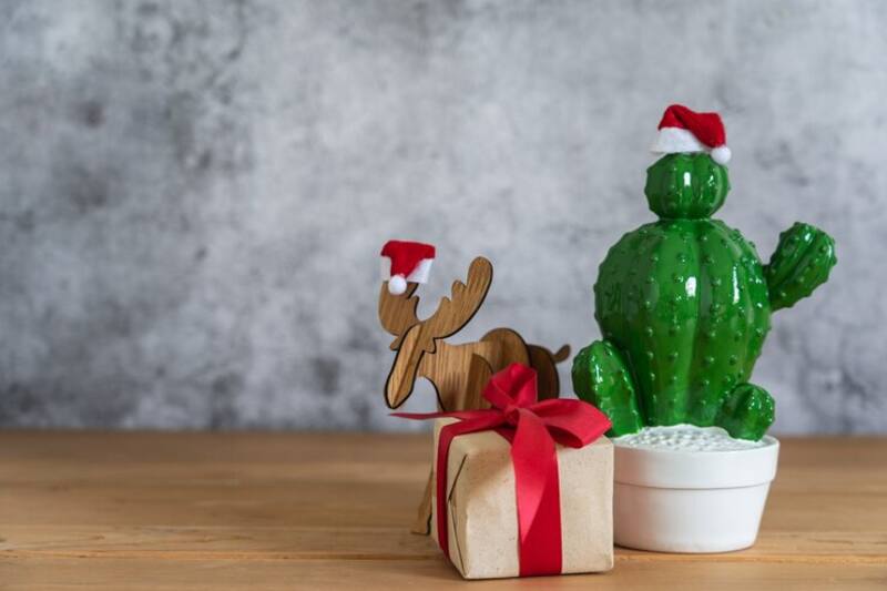 Composición creativa navideña sin árbol: guirnaldas, velas y figuras decorativas en una estantería. (Imagen: archivo)