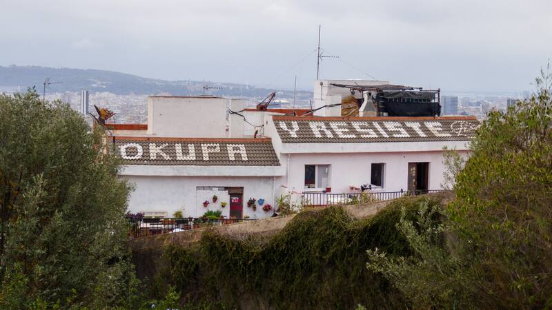 Gaffiti de "okupa y resiste" en el tejado de una casa ocupada, cerca de Parc Guell en Barcelona.