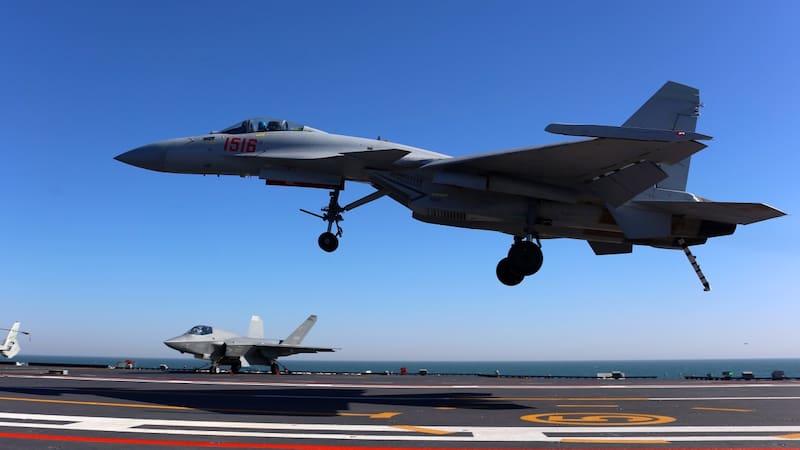 Portaaviones Fujian: un caza J-15T aterriza, mientras un J-35 permanece estacionado detrás.