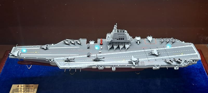 Una maqueta del mega portaaviones Fujian con su grupo aéreo embarcado.