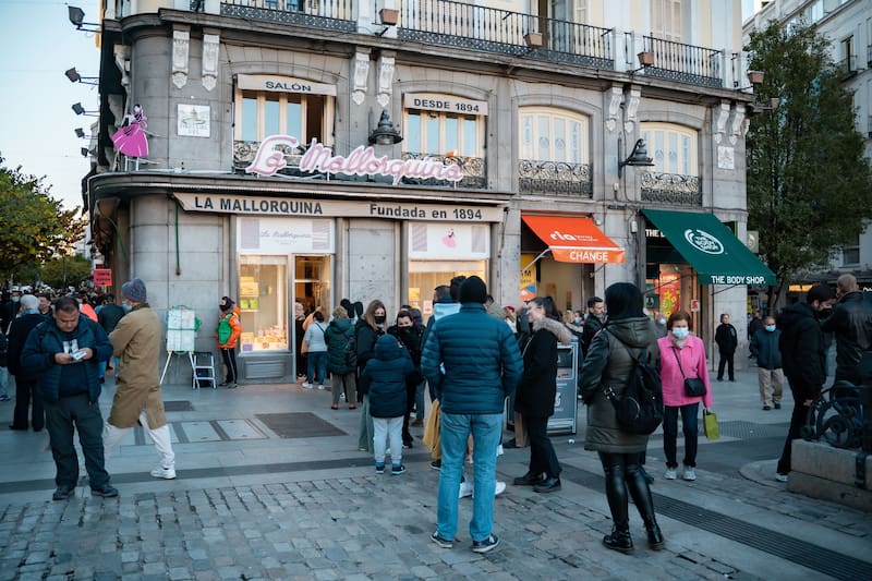 Personas haciendo fila para entrar a La Mallorquina, en Madrid. (Fuente: Shutterstock)