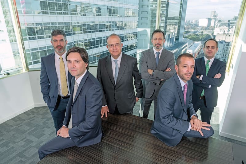 "El RIGI es el mejor régimen de promoción de inversiones que tuvo la Argentina en su historia", no duda José Martínez de Hoz (parado, al centro), fundador de Martínez de Hoz & Rueda (MHR). Con fuerte impronta en la industria energética, el estudio está en los principales asuntos que hoy movilizan a esa industria, desde la inversión en la planta de gas licuado de YPF con Petronas, a la presentación de ofertas para otros clientes en la licitación de áreas convencionales de la petrolera y el proceso de venta de los activos de ExxonMobil en Vaca Muerta.