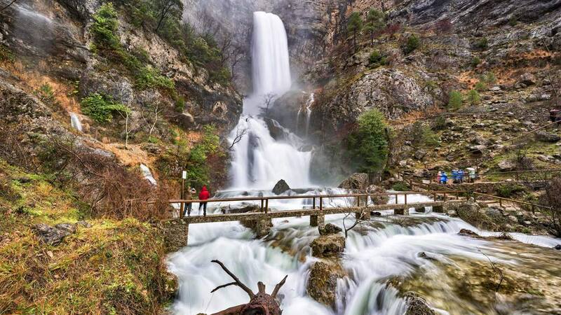El río emerge de una cueva para desembocar en una impresionante cascada.