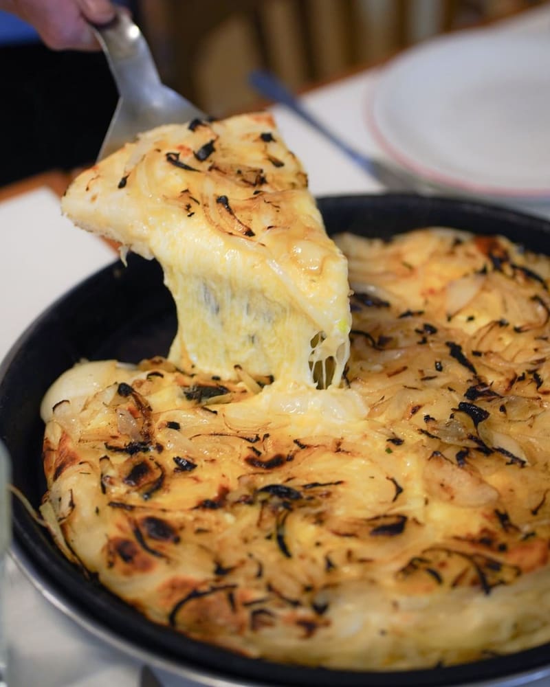 Pizzería Burgio, fundada en 1932, es un ícono en Belgrano, reconocida por su pizza al molde y media masa para su fugazzeta (Fuente: @burgiopizzeria / Instagram)