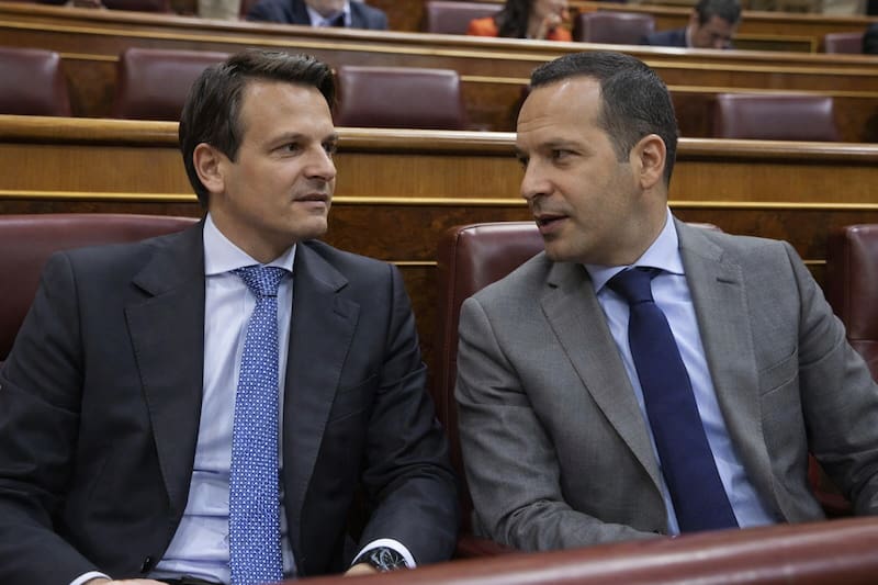 Abel Bautista (Partido Popular) y Óscar Fernández Calle (Vox) dialogan en el Congreso de los Diputados de España. Simulación hecha con IA.