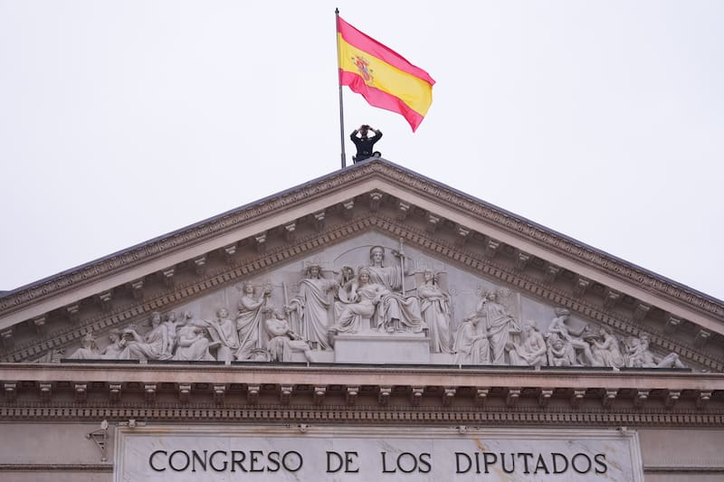 MADRID, 06/12/2025.- Un miembro de las fuerzas de seguridad del Estado sobre el frontispicio del Congreso vigila los alrededores de la Cámara antes del acto institucional por el Día de la Constitución, al que asistirán el presidente del Gobierno, Pedro Sánchez, y el líder de la oposición, Alberto Núñez Feijóo, entre otros dirigentes políticos, en una jornada marcada este año por una profunda división política, con la crispación en máximos y en medio de un ambiente electoral por el arranque de la campaña de las elecciones en Extremadura. EFE/Borja Sánchez-Trillo