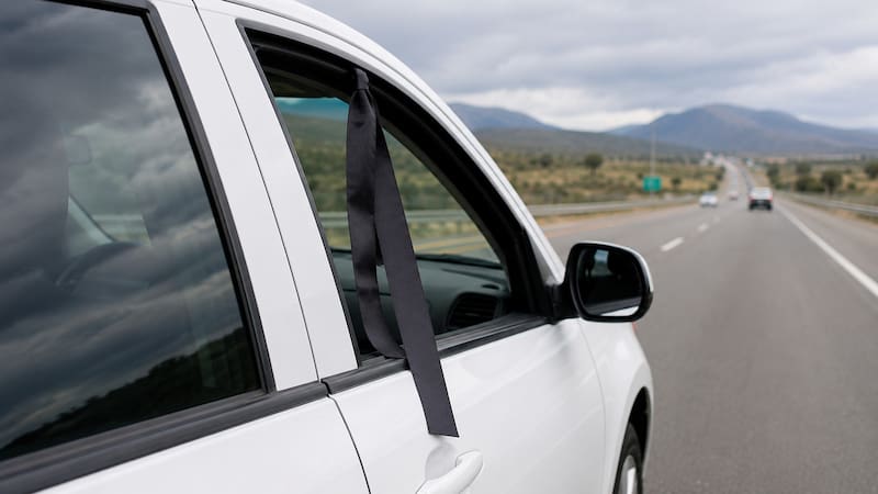 Qué significa ver una cinta negra colgando de la ventana de un auto en la ruta. (Representación creada con IA)
