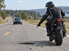 Qué significa que un motociclista señale con la mano hacia el piso y cómo actuar correctamente