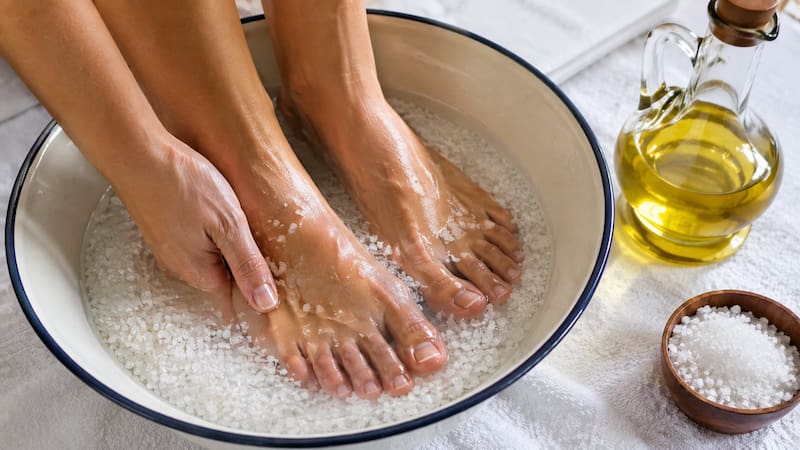 Baño de pies con agua tibia, sal y aceite de oliva como parte de una rutina de cuidado personal.
