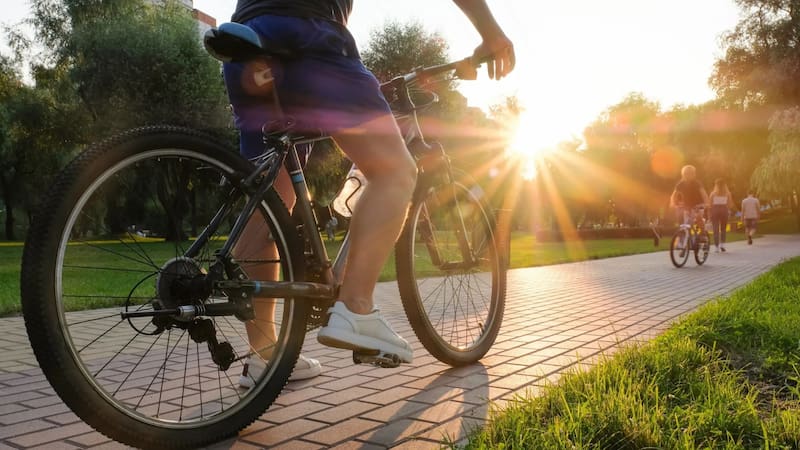 Personas en bicicleta en un parque.