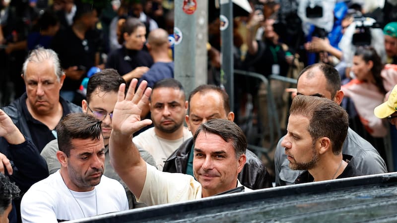 El candidato opositor en las elecciones de Brasil, Flávio Bolsonaro (c) tras votar este domingo en una escuela de Río de Janeiro.