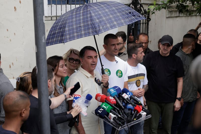 El candidato opositor en las elecciones de Brasil, Flávio Bolsonaro (c) y su mujer Fernanda (c-i) hace declaraciones a los medios tras votar este domingo.