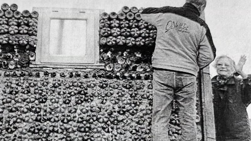 Familiares de Elina Monferrer construyendo las paredes de su casa con botellas de vidrio.