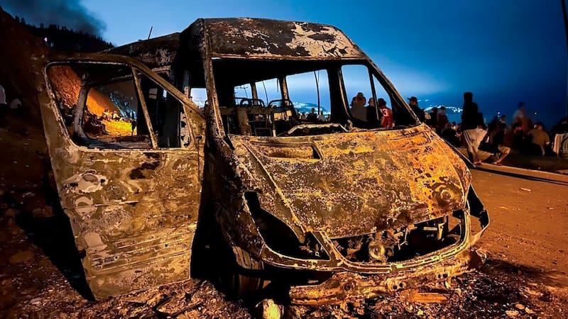 Cerca de la frontera se observaron restos carbonizados de vehículos y un autobús, fruto de violentos enfrentamientos. Foto: EFE.