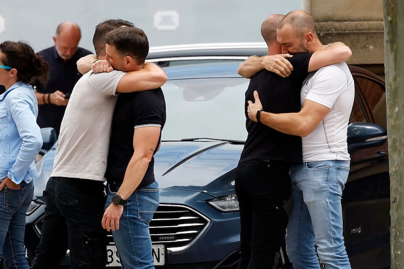 Compañeros de los cinco agentes fallecidos en un accidente de tráfico en Elgoibar se abrazan en la comisaría central de Policía Foral en Beloso, tras conocer el trágico accidente que ha costado la vida a sus compañeros.