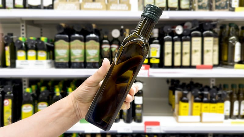choosing olive oil, sauce, vinegar at the grocery store