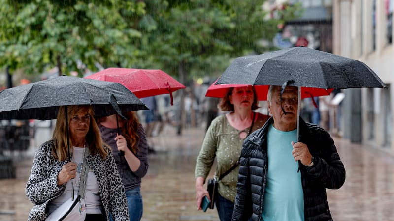 El cielo de la Comunitat Valenciana presentará este jueves un cielo muy nuboso o cubierto, con chubascos acompañados de tormenta en Castellón y Valencia. En la imagen varios turistas se protegen de la lluvia mientras pasean por la plaza del Ayuntamiento de València. EFE/Manuel Bruque