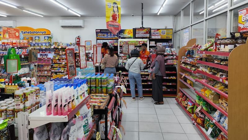 TULUNGAGUNG, INDONESIA - April 10, 2026: Customers queuing at a checkout counter in a bright, modern convenience store.