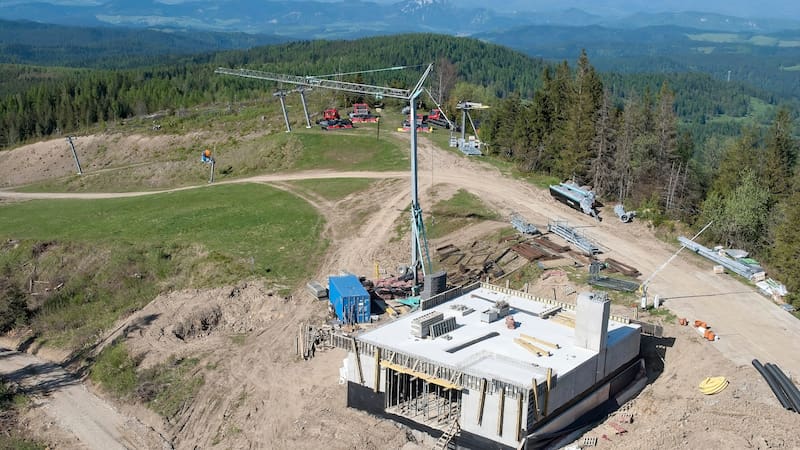 Construction work on a mountainside. Heavy construction equipment on a construction site, high in the mountains among the forest. Infrastructure development