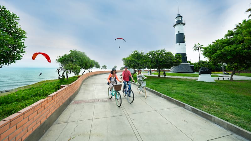 Turistas paseando en bicicleta por el malecón de Miraflores