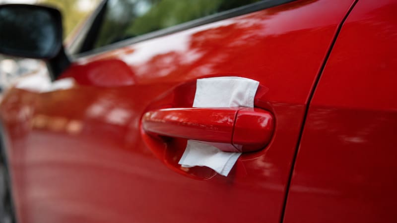 La reacción automática al ver una servilleta o papel sobre la manija del auto sería retirarla y subir al vehículo sin darle demasiada importancia