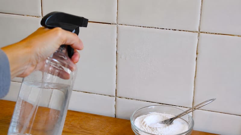 Rociar agua con bicarbonato de sodio en las juntas de los azulejos.