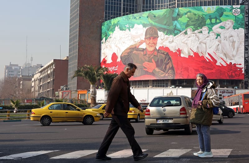 Personas caminan frente a un cartel que retrata al excomandante de la Fuerza Quds del Cuerpo de la Guardia Revolucionaria Islámica de Irán (IRGC), Qasem Soleimani, en el centro de Teherán, Irán.