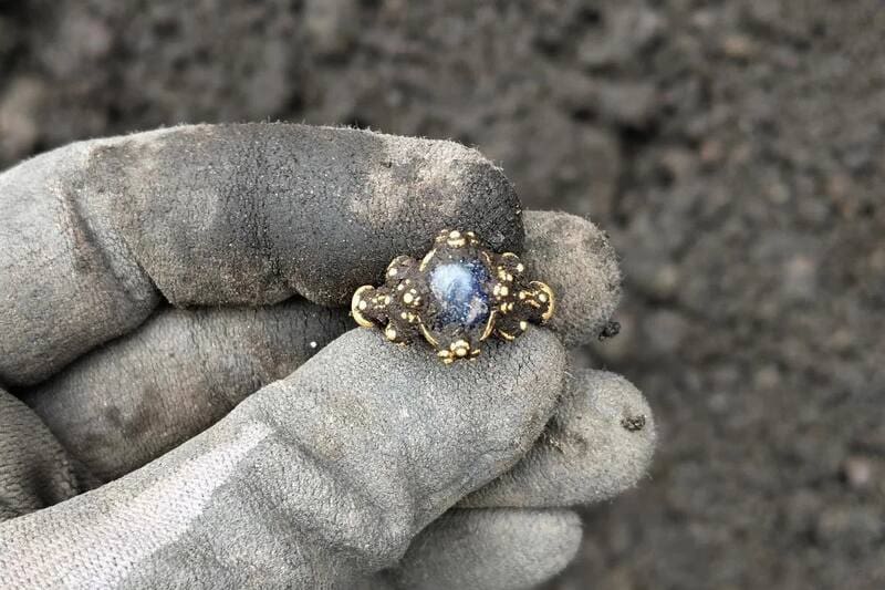 El anillo estaba hecho de oro y tenía incrustada una piedra azul.