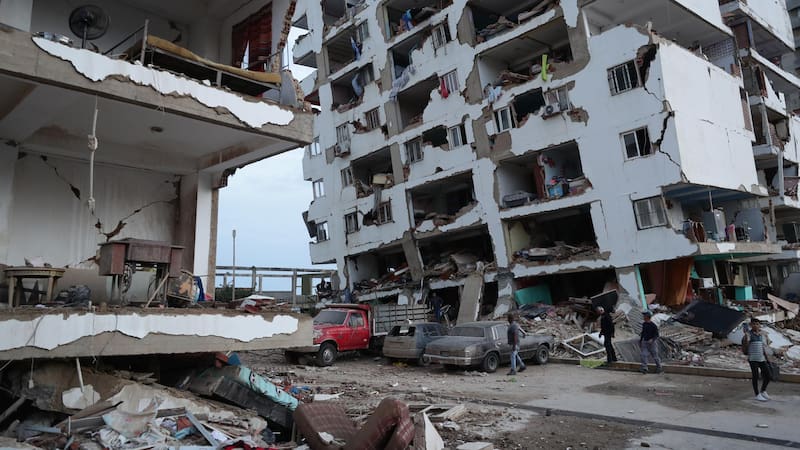 25/06/2026.- Residentes caminan entre los escombros de varios bloques de viviendas dañados por los terremotos en la localidad de Catia La Mar, en el estado costero de La Guaira (Venezuela) este jueves.