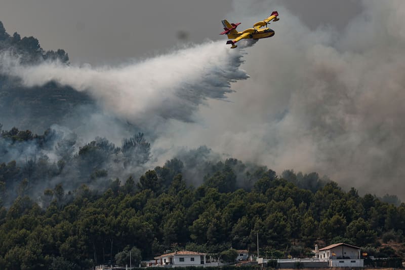 Un hidroavión realiza una descarga de agua en Betxí en el frente del incendio declarado este sábado en la Vall d'Uixó (Castellón), y que lleva quemadas ya unas 4.300 hectáreas y cuyo perímetro supera los 40 kilómetros.