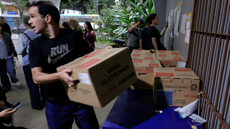 Un hombre carga urnas electrónicas este domingo, en una escuela en Río de Janeiro (Brasil). La segunda vuelta de las elecciones presidenciales en Brasil
