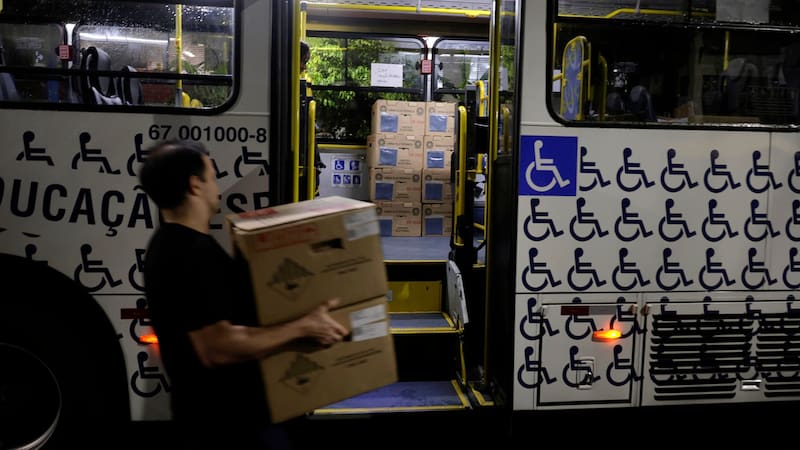 Personas cargan urnas electrónicas este domingo, en una escuela en Río de Janeiro (Brasil).