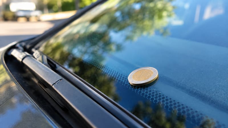 Encontrar una moneda en el vidrio del auto