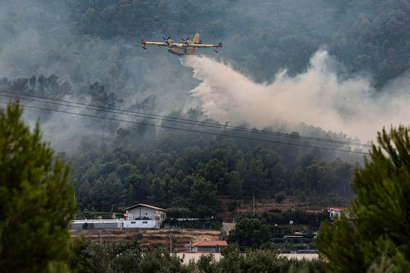 Un hidroavión realiza una descarga de agua en Betxí, España, en el frente del incendio declarado este sábado en la Vall d'Uixó (Castellón), y que lleva quemadas ya unas 4.300 hectáreas y cuyo perímetro supera los 40 kilómetros.