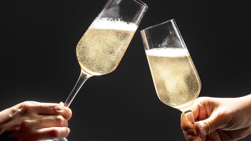 Couple celebrating with champagne on dark background