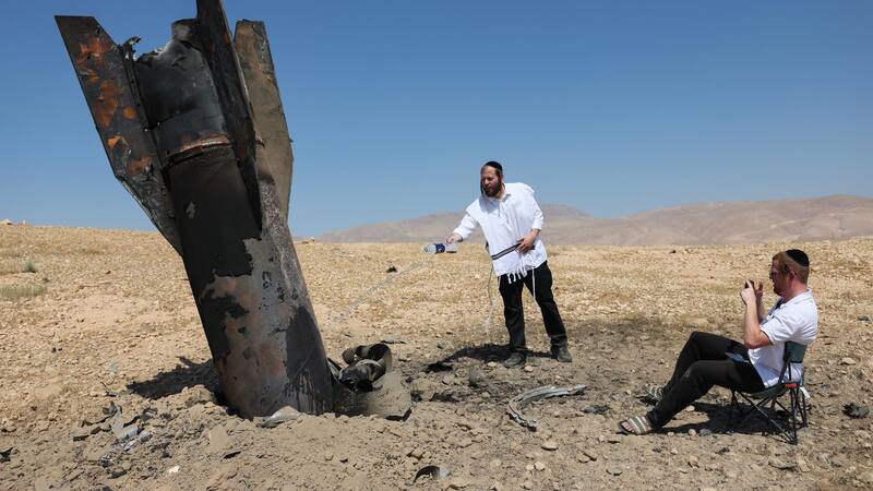 Judíos ultraortodoxos observan los restos de un misil balístico iraní que cayó en un campo abierto junto a Cisjordania.