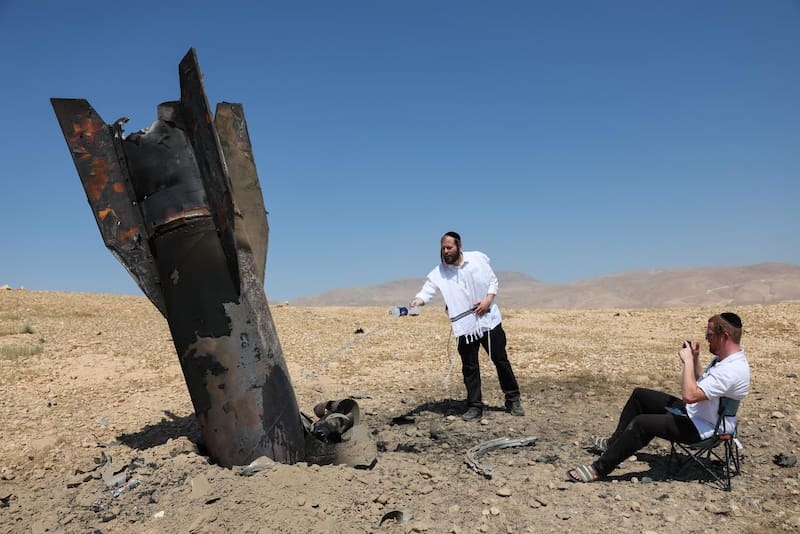 Judíos ultraortodoxos observan los restos de un misil balístico iraní que cayó en un campo abierto junto a Cisjordania.