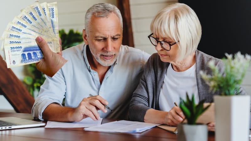 Excited elder family pensioner couple read and check financial document, calculate profit, saving income from investment. OAP Senior man and woman do monthly paperwork, make utility payment online