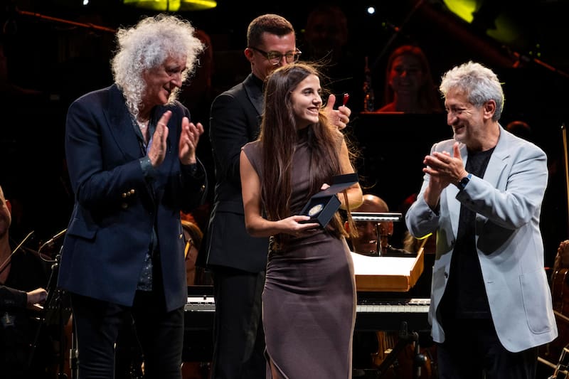 La joven divulgadora científica y tecnológica española Valeria Corrales (c) recibe la Medalla Junior Stephen Hawking de manos del astrofísico Garik Israelian (d) y del astrofísico y guitarrista de Queen Brian May (i), este sábado durante el festival científico Starmus en Santa Cruz de Tenerife.