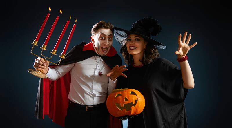 Dos personas disfrazadas para Halloween con una calabaza.
